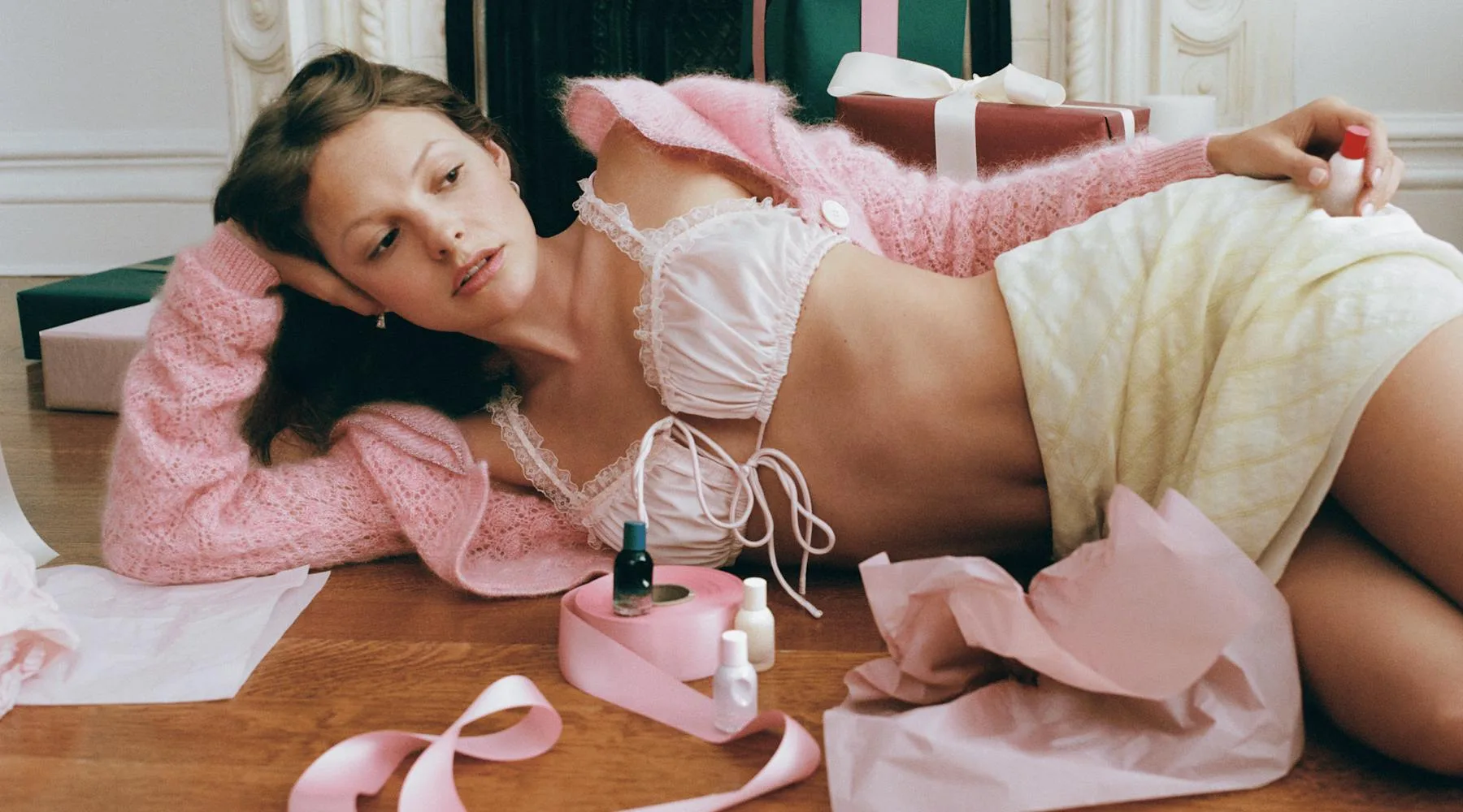 Glossier holiday collection campaign with pink knitwear and festive fragrance gifts